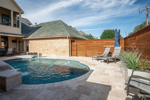 view of swimming pool with pool water feature and a patio area