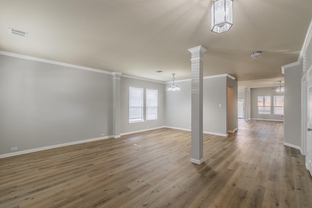 empty room with crown molding, dark wood-type flooring, decorative columns, and ceiling fan