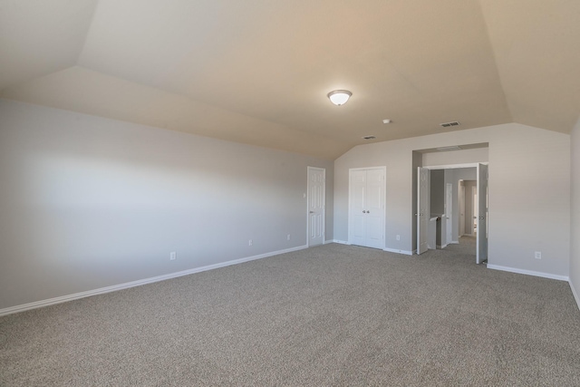 carpeted spare room featuring lofted ceiling