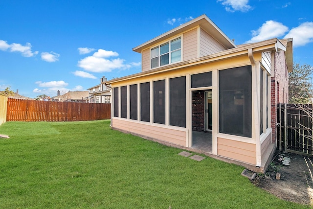 back of property with a sunroom and a yard