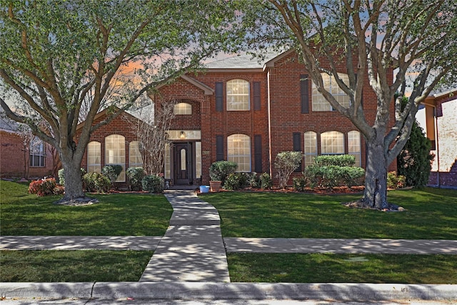 view of front of property with brick siding and a front lawn