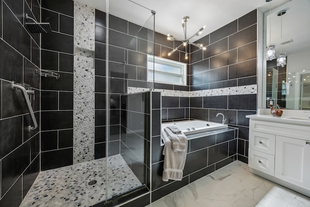 bathroom with an inviting chandelier, vanity, tile walls, and shower with separate bathtub