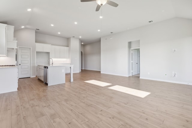 unfurnished living room with vaulted ceiling, ceiling fan, sink, and light hardwood / wood-style floors