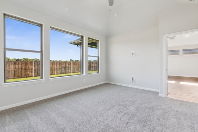 carpeted empty room featuring ceiling fan and lofted ceiling