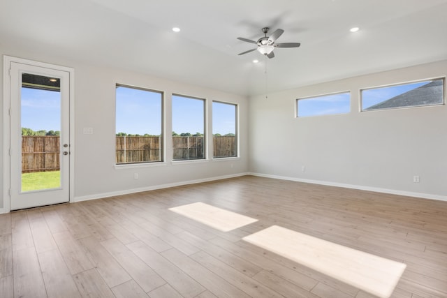 spare room featuring a wealth of natural light, light hardwood / wood-style floors, and ceiling fan