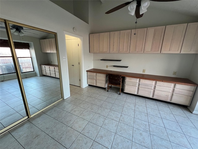 kitchen featuring built in desk, high vaulted ceiling, ceiling fan, and light tile patterned flooring