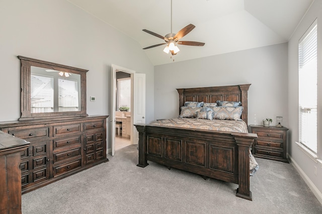 carpeted bedroom with multiple windows, lofted ceiling, and ensuite bath