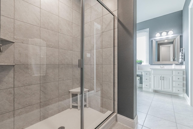 bathroom with tile patterned flooring, vanity, and walk in shower