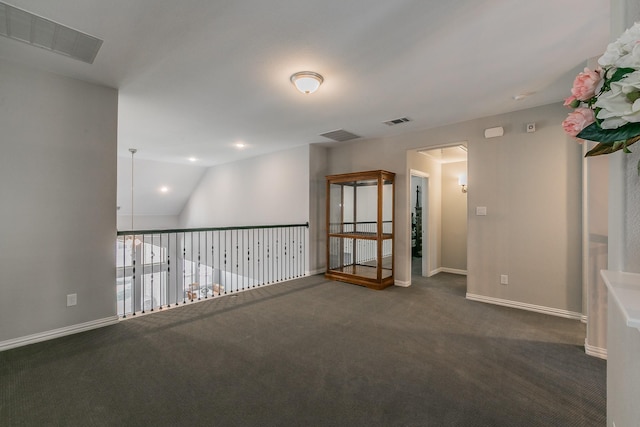 carpeted spare room with vaulted ceiling