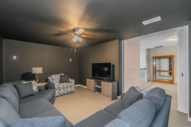 carpeted living room featuring a textured ceiling and ceiling fan