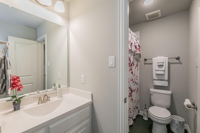 bathroom featuring vanity, toilet, and walk in shower