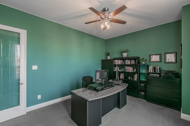 carpeted office space featuring ceiling fan