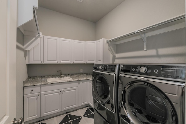 washroom with cabinets, sink, light tile patterned floors, and washer and dryer