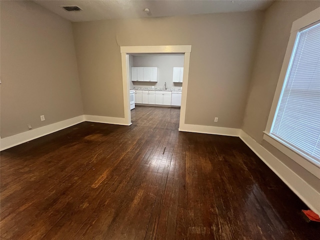 empty room with dark hardwood / wood-style flooring and sink