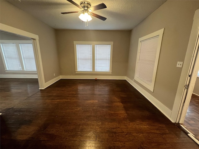 empty room with ceiling fan, dark hardwood / wood-style floors, and a textured ceiling