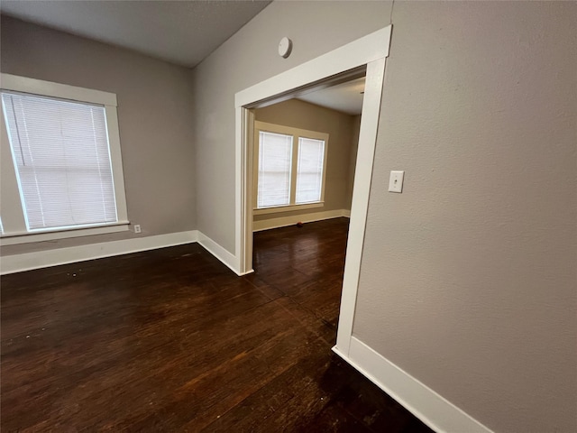 empty room with dark hardwood / wood-style flooring