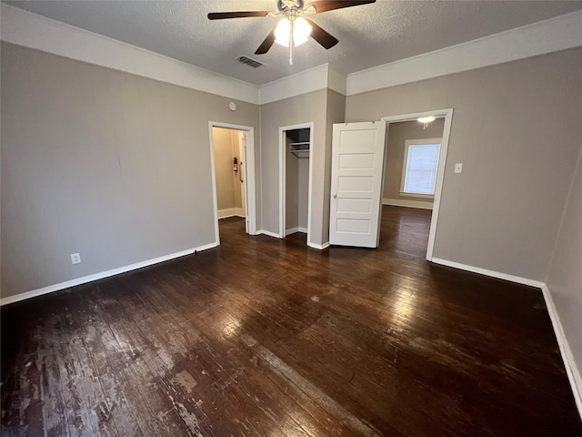 unfurnished bedroom featuring ceiling fan, a closet, dark hardwood / wood-style floors, and a textured ceiling