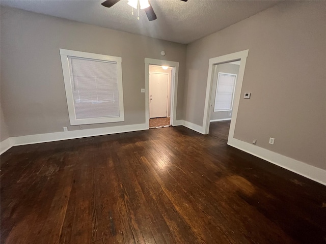 unfurnished room featuring dark wood-type flooring, a textured ceiling, and ceiling fan