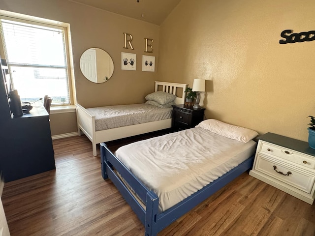 bedroom with lofted ceiling and dark wood-type flooring