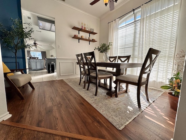 dining area featuring light hardwood / wood-style flooring, ceiling fan, and crown molding