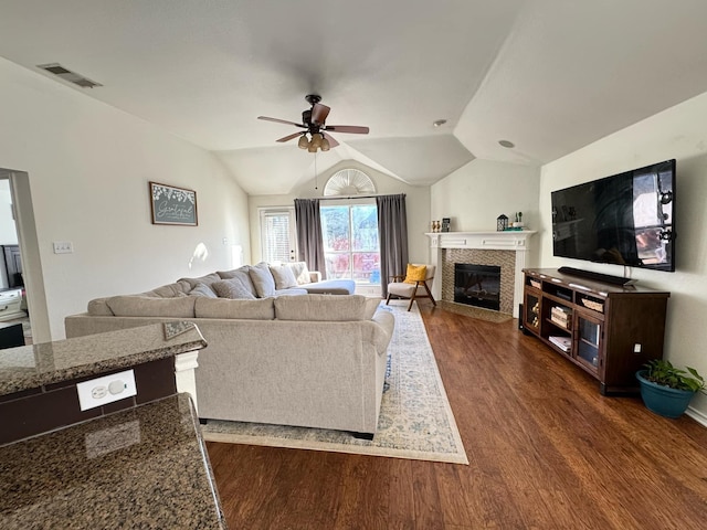 living room with lofted ceiling, ceiling fan, and dark wood-type flooring