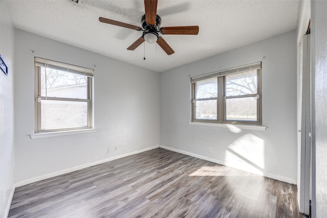 spare room featuring ceiling fan, wood-type flooring, and a textured ceiling