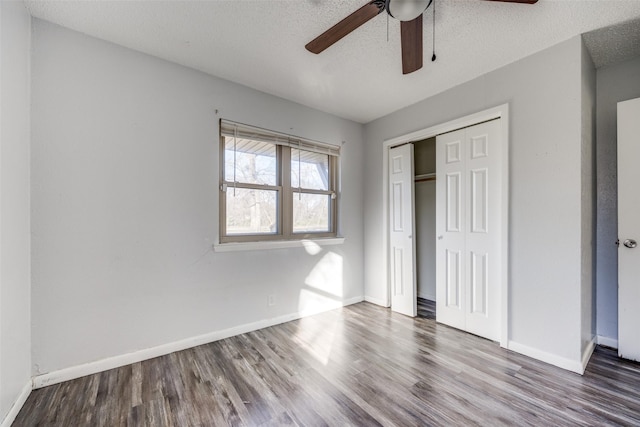 unfurnished bedroom with ceiling fan, hardwood / wood-style floors, a closet, and a textured ceiling