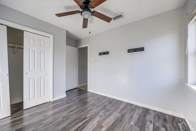 unfurnished bedroom featuring hardwood / wood-style flooring, a closet, and ceiling fan