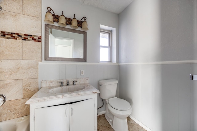 bathroom featuring vanity, toilet, and a textured ceiling