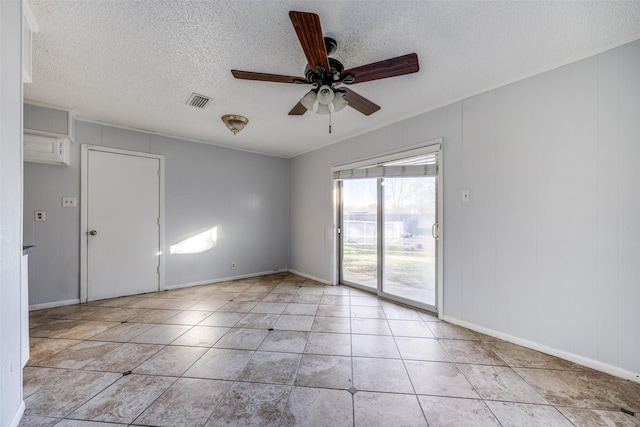 unfurnished room with ceiling fan, light tile patterned floors, and a textured ceiling