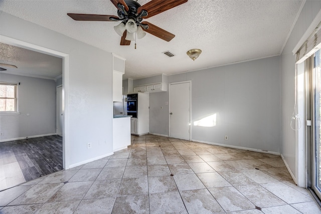 unfurnished living room featuring crown molding, ceiling fan, a textured ceiling, and light tile patterned floors