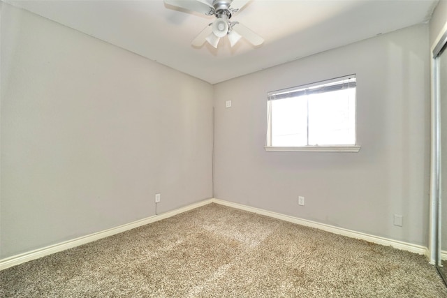 carpeted spare room featuring ceiling fan