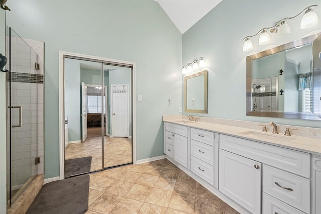 bathroom with vanity, vaulted ceiling, and walk in shower