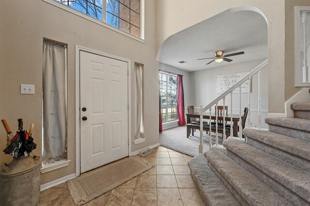 foyer featuring light tile patterned floors, a textured ceiling, and ceiling fan