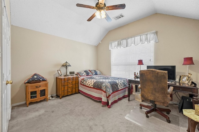 bedroom with ceiling fan, lofted ceiling, light colored carpet, and a textured ceiling