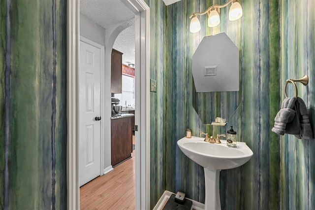 bathroom with wood-type flooring and a textured ceiling