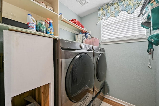 laundry room with wood-type flooring and separate washer and dryer