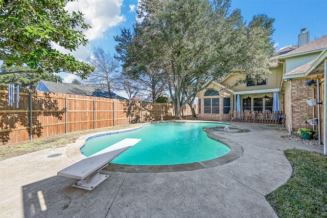 view of swimming pool with a diving board, ceiling fan, and a patio