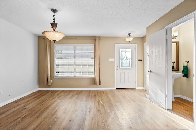 entrance foyer with light wood-type flooring and a textured ceiling