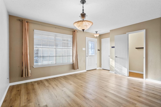 foyer entrance featuring light hardwood / wood-style floors and a textured ceiling