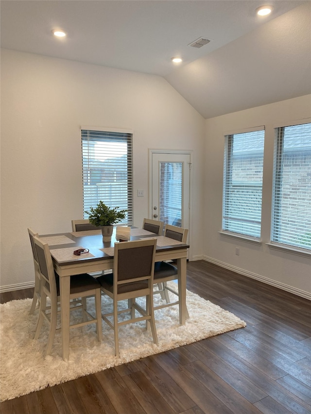 dining space with dark hardwood / wood-style flooring and lofted ceiling