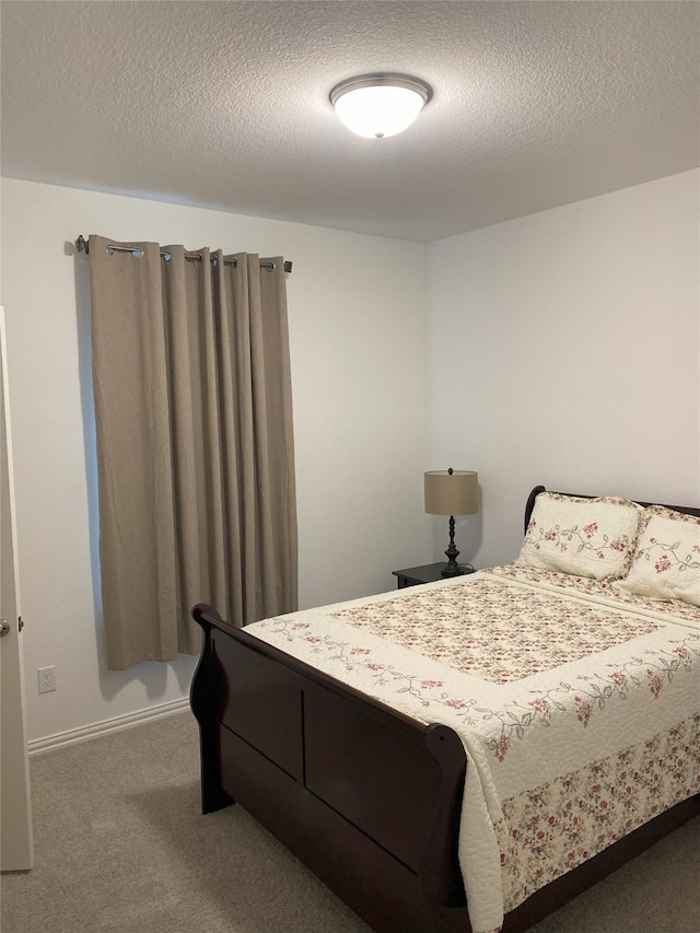 bedroom with carpet and a textured ceiling