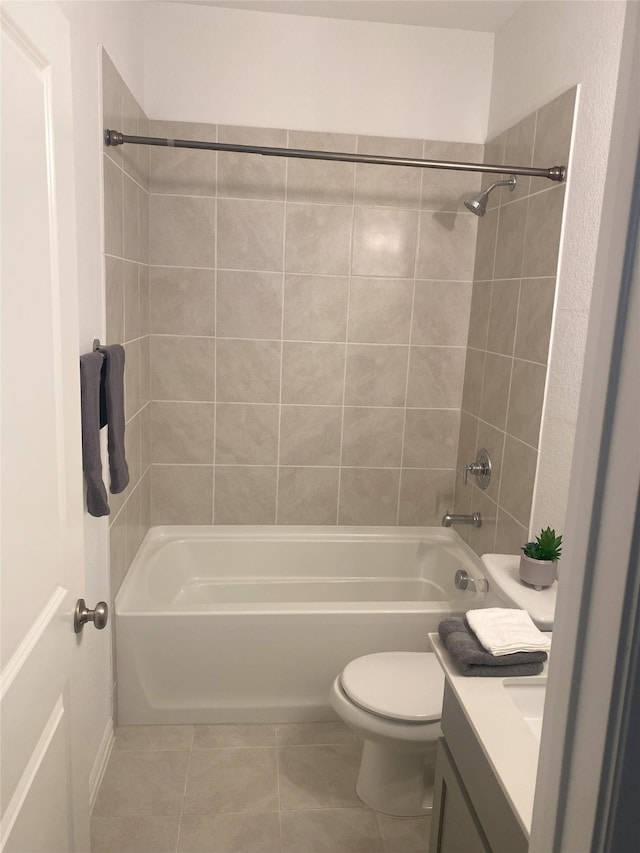 full bathroom featuring tile patterned flooring, vanity, tiled shower / bath combo, and toilet