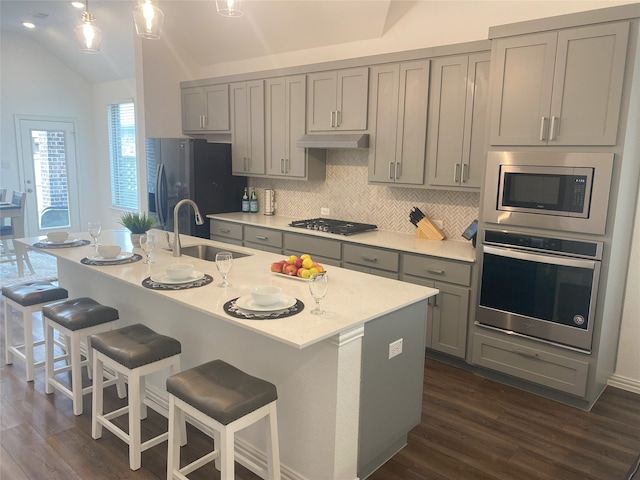 kitchen featuring gray cabinetry, stainless steel appliances, lofted ceiling, and sink