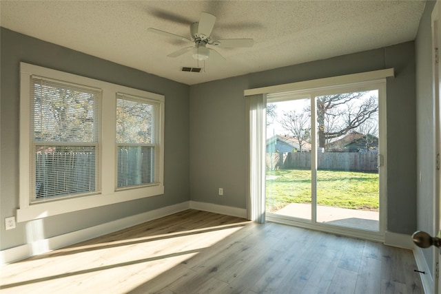 interior space featuring ceiling fan, a textured ceiling, and light wood-type flooring