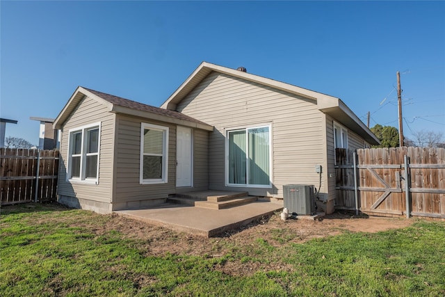 rear view of house with a lawn, a patio, and central air condition unit