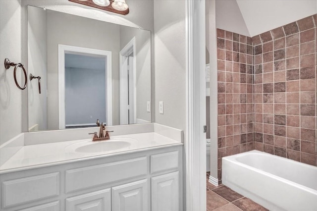 bathroom with lofted ceiling, tile patterned floors, vanity, and bathtub / shower combination