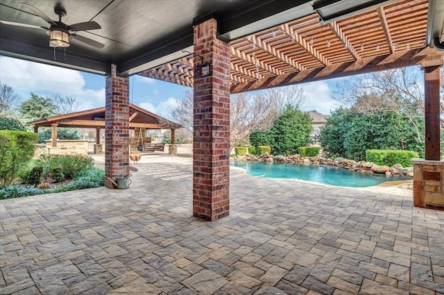 view of swimming pool featuring ceiling fan, pool water feature, a pergola, and a patio