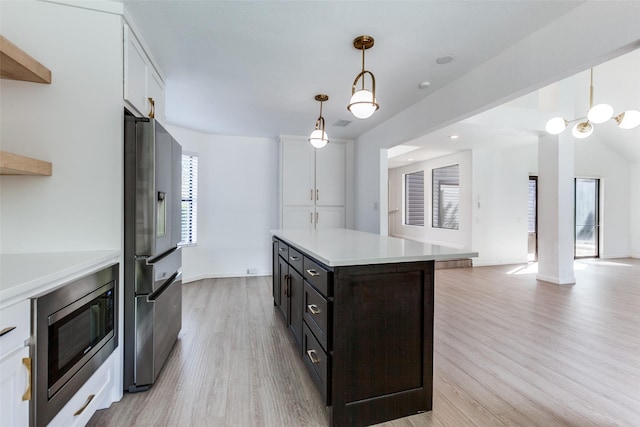 kitchen with white cabinets, a center island, hanging light fixtures, and appliances with stainless steel finishes