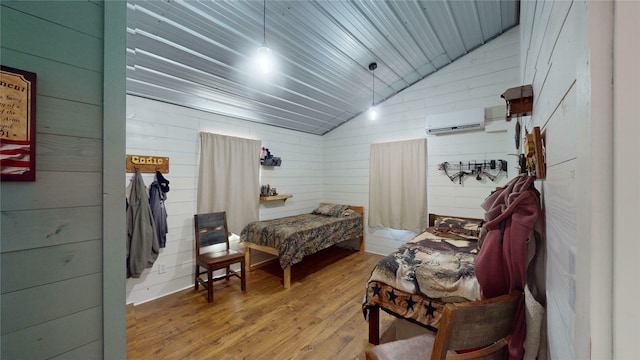 bedroom with lofted ceiling, wood walls, a wall unit AC, hardwood / wood-style floors, and wood ceiling